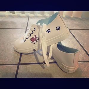 Cute white kid shoes with cat prints on the sides
